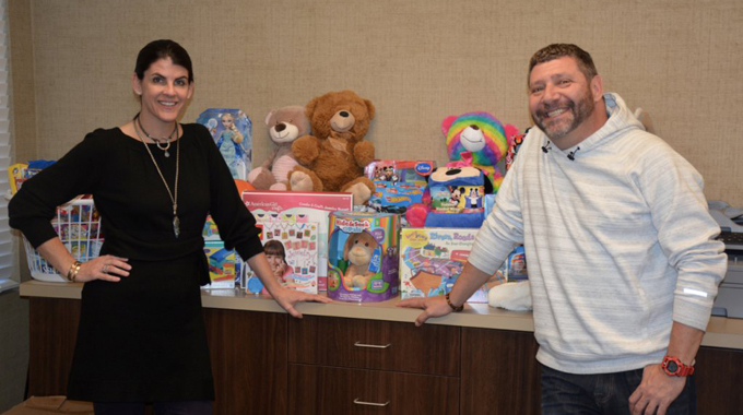 Corinne Howington of Low Country Dermatology presents donations collected for the Ronald McDonald House to executive director Bill Sorochak