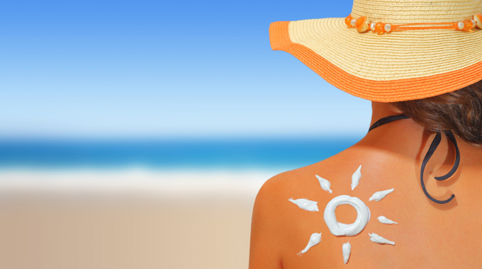 Woman with sunscreen on her back in the shape of the sun.